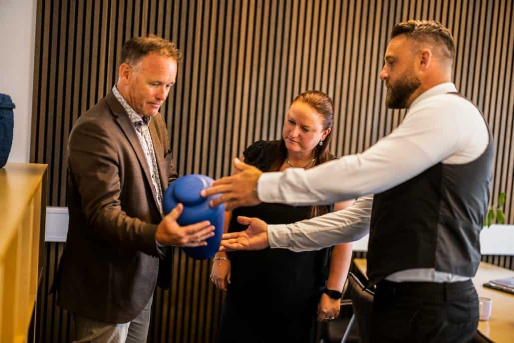 Bedemand viser blå urne frem